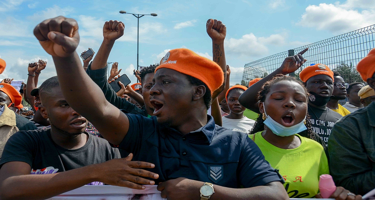 Close up photo of a group of protesters holding a banner, fists up.