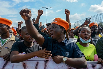 Close up photo of a group of protesters holding a banner, fists up.